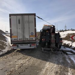 Pomoc drogowa w wyciąganiu ciężarówki z naczepą z powrotem na błotnistą drogę w pogodny dzień w pobliżu Trzebnicy.